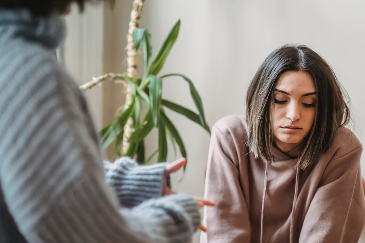 sad teen girl sitting talking to an adult